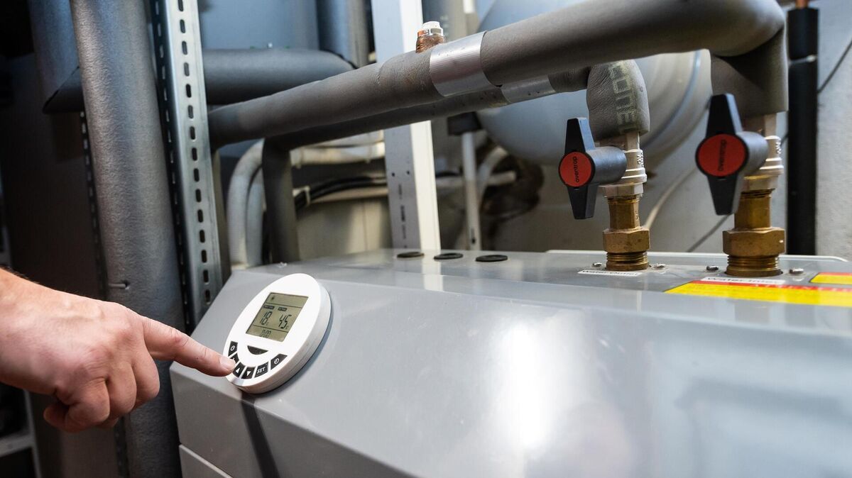 Ein Mann bedient eine Luftwärmepumpe. Das könnte eine Alternative für eine neue Heizung auch in Ihrem Haus sein. Foto: Stein/dpa