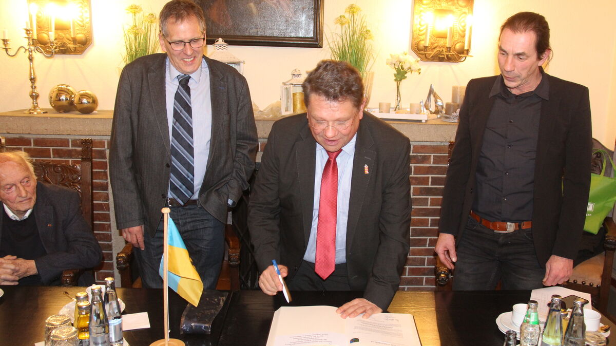 Sozialminister Dr. Philippi beim Eintrag in das Goldene Buch, fnkiert von Bürgermeister Claus Johannßen und Stadtdirektor Frank Thielebeule (l.). Mit am Tisch Ehrenbürgermeister Hermann Gerken (l.). Foto: Kramp