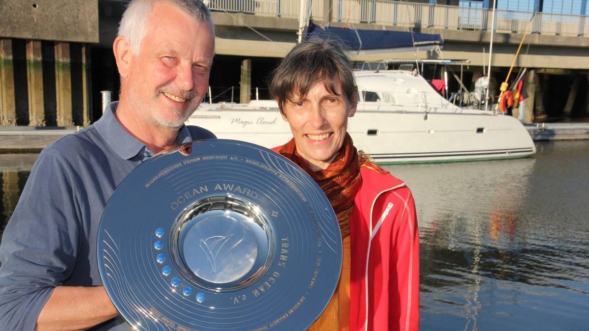 Johannes Frost und Ehefrau Andrea Finke nahmen im Cuxhavener Seglerhafen den "Ocean Award" entgegen. Den Wanderpreis verleiht der Verein Trans Ocean an Menschen, die sich in besonderer Weise um den Segelsport verdient gemacht haben. Im Hintergrund ihr Katamaran "Magic Cloud". Foto:Sassen
