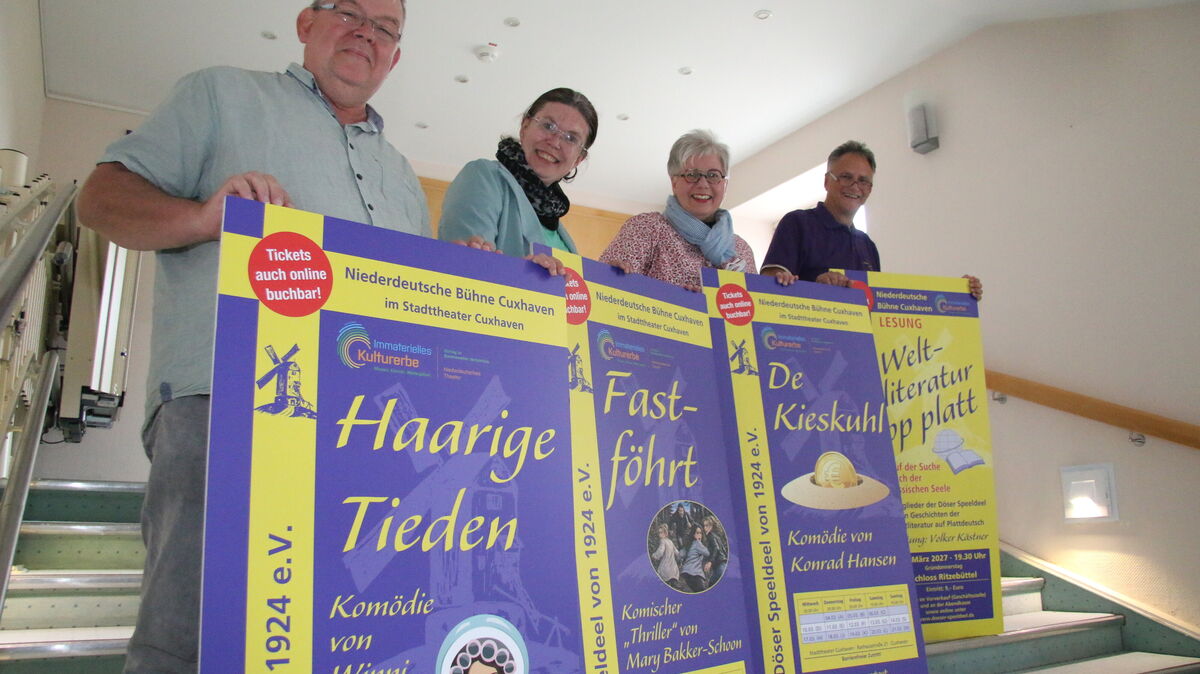 Frank Siemer-Bosecker, Maike Bruns, Andrea Hinke und Volker Kästner von der Döser Speeldeel präsentieren sich auf der Theatertreppe im Foyer des Stadttheaters Cuxhaven. Vor der Brust halten sie die Plakate zu den drei Stücken der neuen Spielzeit sowie zur Lesung „Weltliteratur op Platt“, die am Gründonnerstag 2027 im Schloss Ritzebüttel stattfindet.