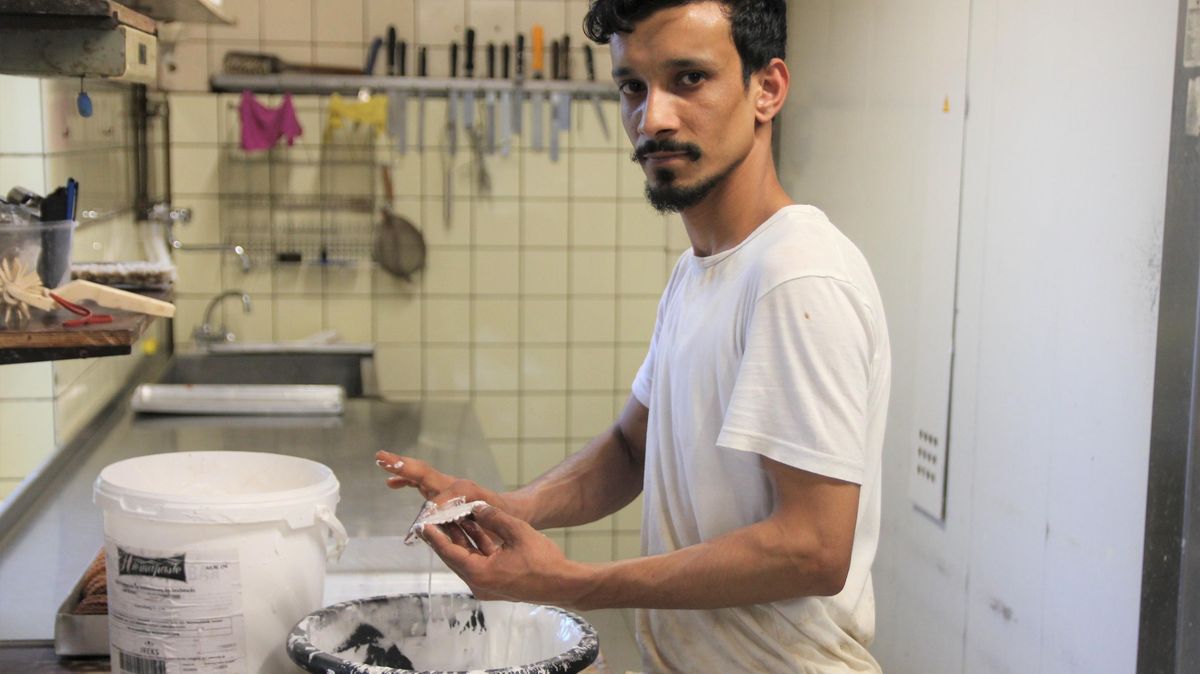 Beliebte norddeutsche Spezialität: Ebrahim Miah (22) aus Bangladesch beim Glasieren der "Braunen Kuchen" in der Bäckerei Buck in Bülkau. Foto: Grewe