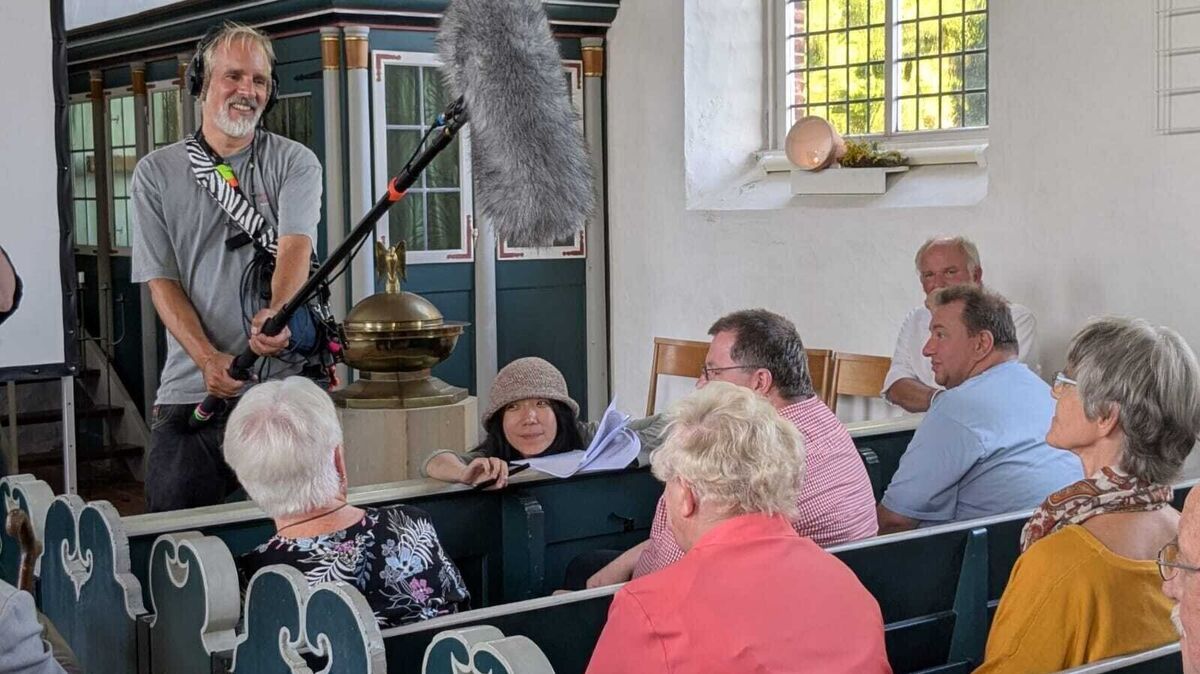 Die Dreharbeiten in der Kehdingbrucher Kirche waren für Regisseurin Xiaoxue Li (mit Hut) und ihr Team eine besondere und schöne Erfahrung. Foto: Nebenan Film