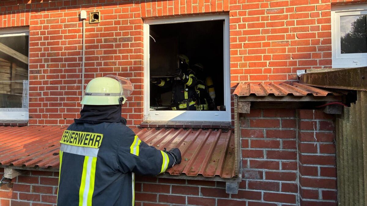 Feuerwehrkräfte erkunden unter Atemschutz das verrauchte Gebäude nach einem Küchenbrand in der Jahnstraße in Osten. Foto: Lange