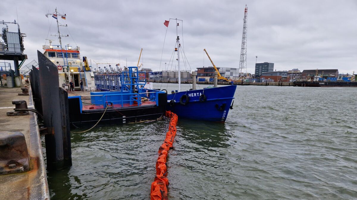 Eine Ölsperre soll verhindern, dass sich der ausgelaufene Treibstoff weiter im Hafenbecken von Cuxhaven ausbreitet. Foto: Larschow