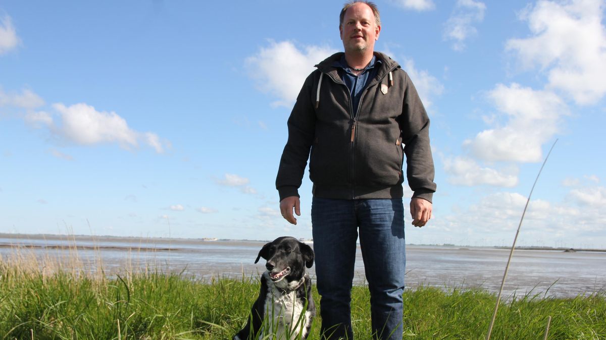 Joachim Schlichting auf seinem Land an der Elbe bei Belum, mit Bonny, der Border-Collie-Münsterländer-Hündin. Foto: Grewe