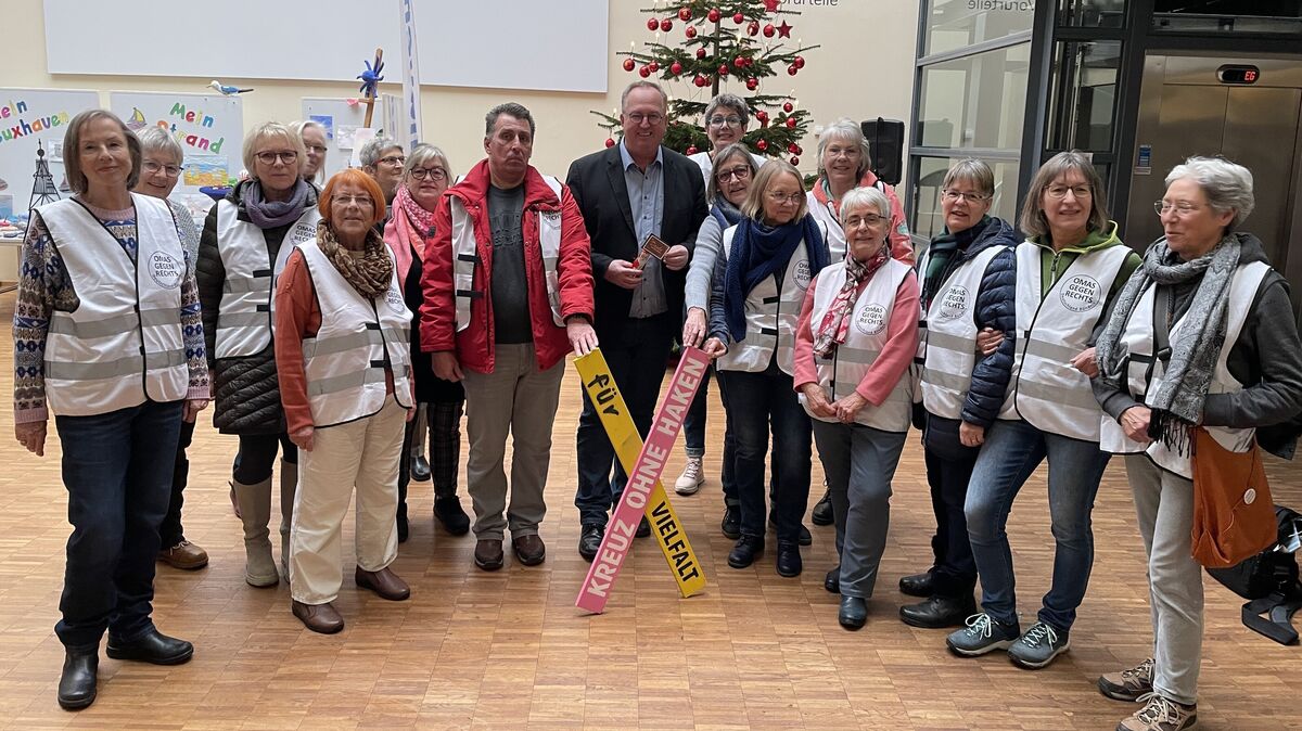 Vor dem Weihnachtsbaum und den Cuxhavener Thesen für ein gutes Miteinander übergaben die "Omas gegen Rechts" das erste "Kreuz ohne Haken" in der Stadt Cuxhaven an Oberbürgermeister Uwe Santjer. Foto: Reese-Winne