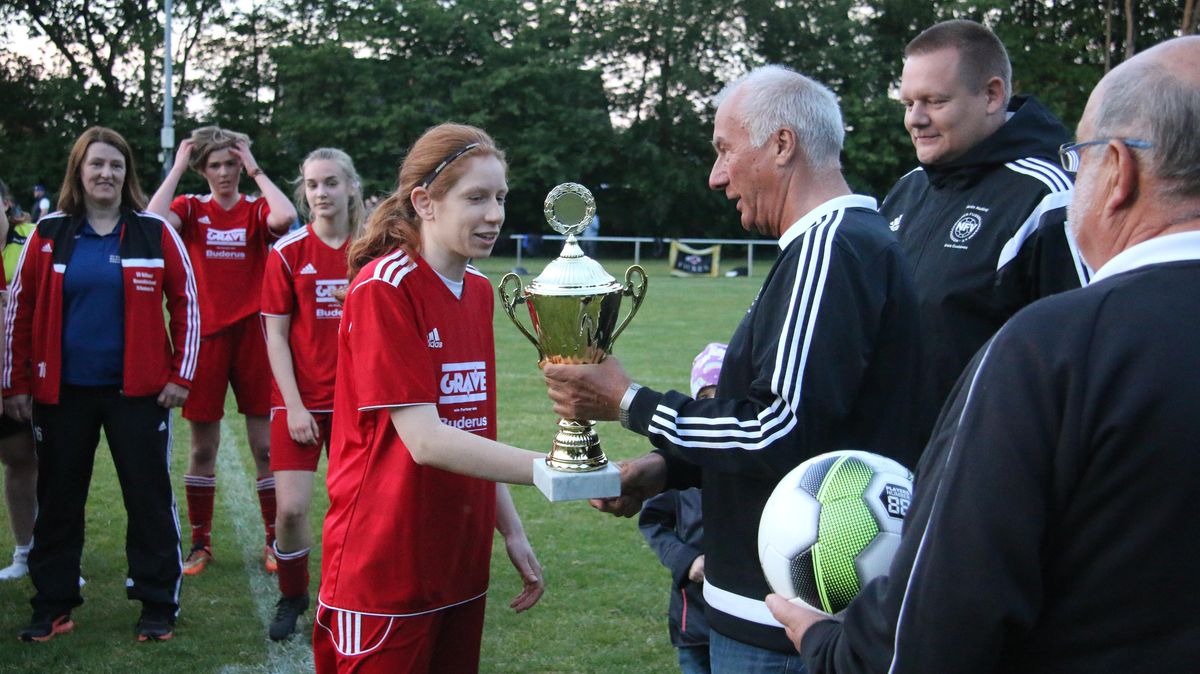 NFV-Kreisvorsitzender Walter Kopf überreicht den Kreispokal an Finja Petersen, die Kapitänin der SG Bülkau/Neuenkirchen-Ihlienworth. Foto: Lütt