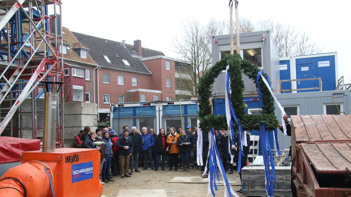 Der mit blau-weißen Schleifen verzierte Richtkranz wurde von einem Baukran in luftige Höhen bewegt. Foto: Potschka
