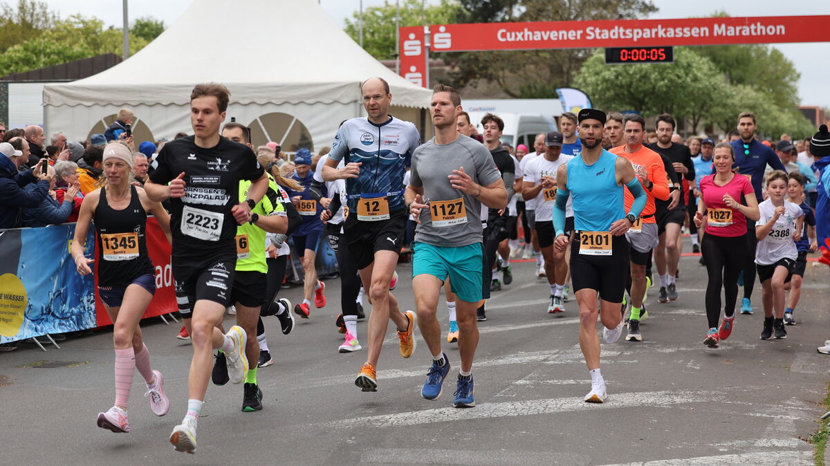 Teilnehmende des Cuxhaven Marathons 2025 trotzen stürmischem Wind bei der neuen Strecke am Deich. Foto: May