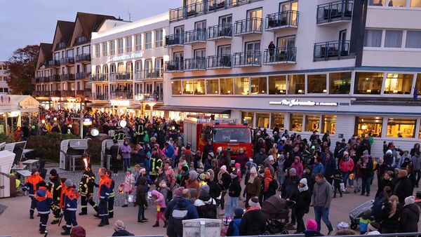 Duhnen im Kerzenschein: Laternen, Stelzenläufer und Dudelsackspieler am Dorfbrunnen