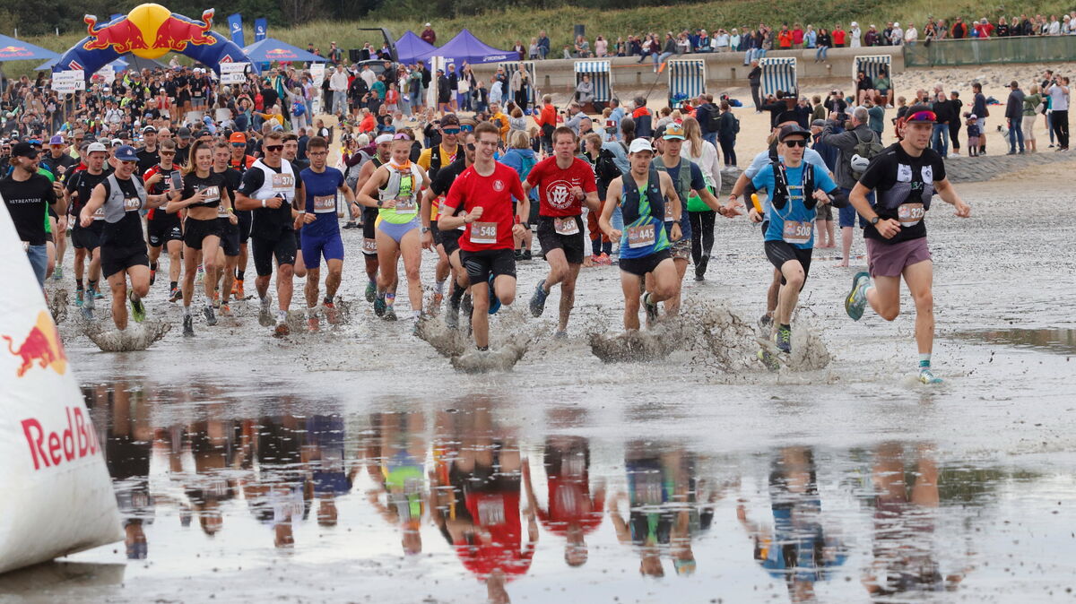 Neuland für aus dem Binnenland angereiste Läuferinnen und Läufer: Der Schritt über den Flutsaum ins noch immer von einem Wasserfilm bedeckte Watt. Foto: Koppe