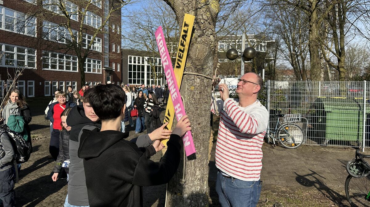 Schülerinnen, Schüler und Lehrkräfte stellten sich symbolisch hinter das "Kreuz ohne Haken", das danach einen festen Platz in der Nähe des Schultors erhielt. Foto: Reese-Winne