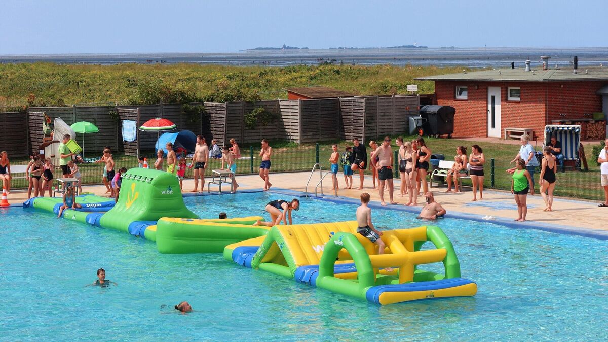 Bei der Poolparty im Meerwasserfreibad Steinmarne nutzen Kinder und Familien die schwimmenden Spielmodule im Becken mit Blick auf die Nordsee. Foto: Tonn