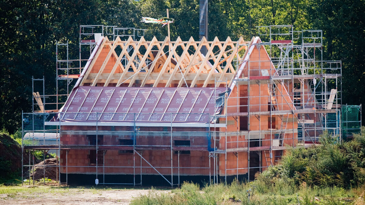 Ein Richtkranz weht am Dachstuhl eines neu gebauten Einfamilienhauses. In Cuxhaven ist Bauplatz rar gesät. Foto: Julian Stratenschulte/dpa