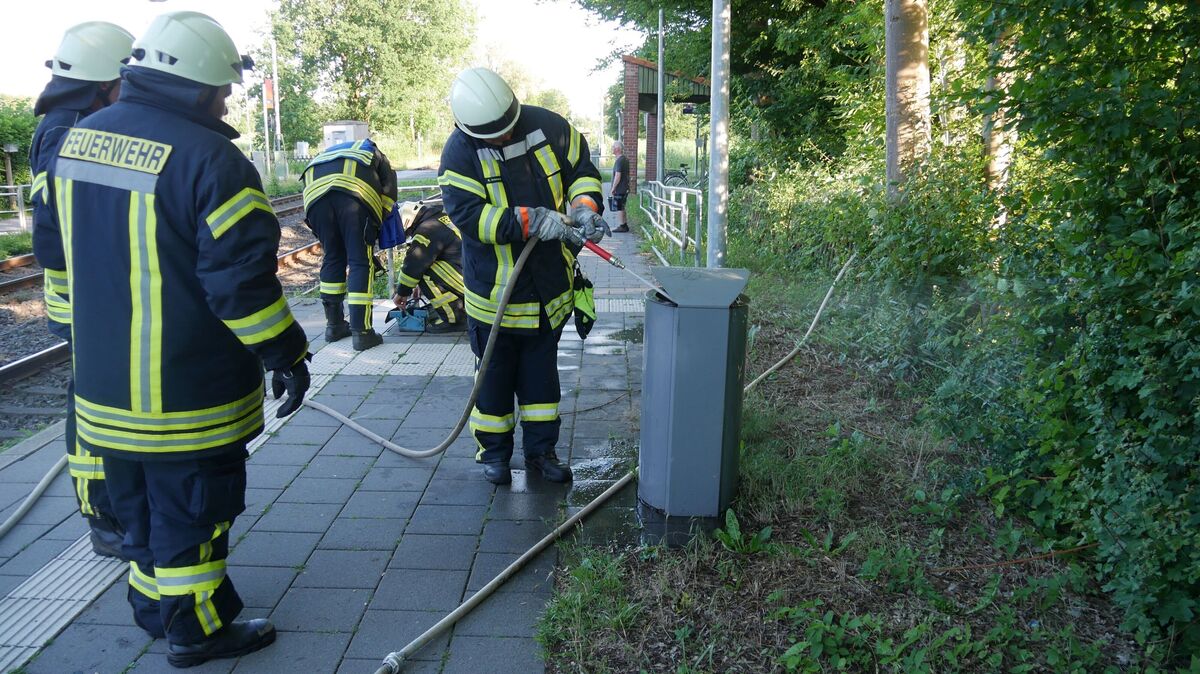 Zunächst wird das Feuer mit einem Eimer Wasser eingedämmt. Parallel dazu wird eine D-Schlauchleitung zu den beiden brennenden Papierkörben verlegt, um beide Feuer endgültig mit reichlich Wasser abzulöschen. Foto: Lange