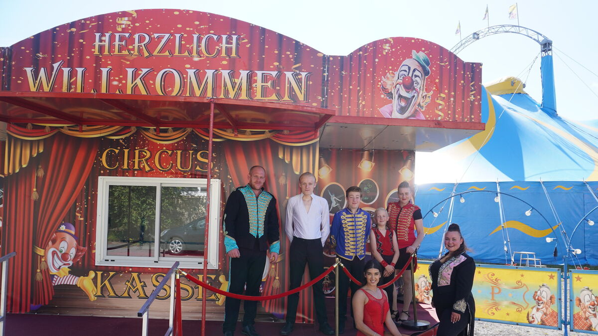 Die Familie Kaselowsky begrüßt die Besucher des Zirkus Pfiffikus in Cuxhaven. Hinter der Bundespolizei ragen ihre Zeltspitzen in den Himmel. Foto: Brettschneider