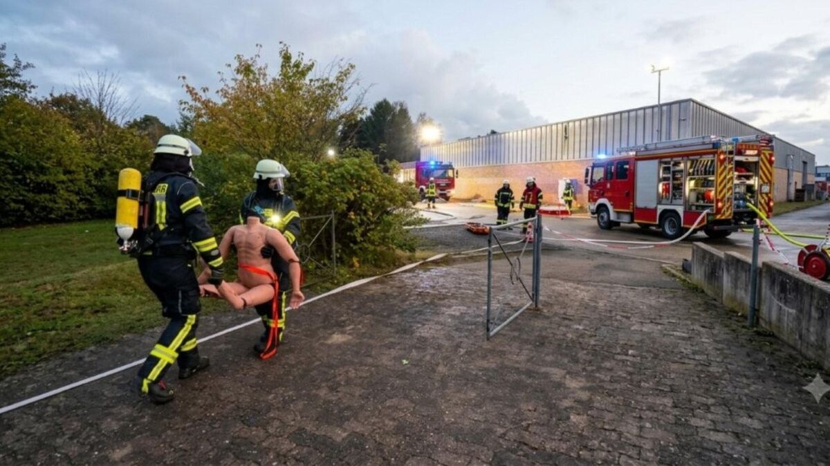 An erster Stelle steht die unmittelbare Menschenrettung aus dem verrauchten Gebäude unter schweren Atemschutz: Einsatzkräfte tragen eine Übungspuppe aus dem Gefahrenbereich. Foto: Lange