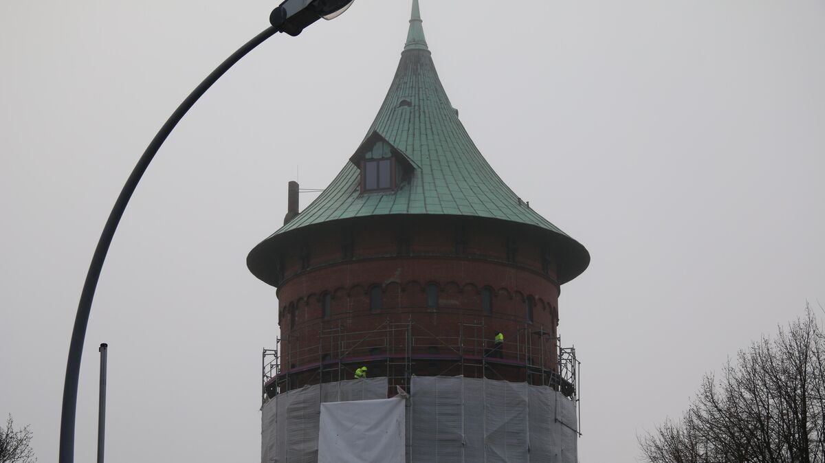 Arbeiter entblättern den Wasserturm und bauen das Gerüst zurück. Foto: Potschka
