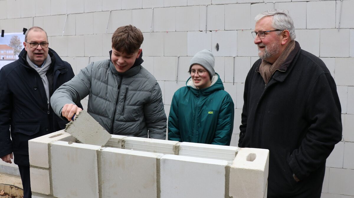 Unter den Augen des Landrats Thorsten Krüger (links) und des Schulausschuss-Vorsitzenden Axel Quast (rechts) griffen die Schülersprecher Jule Rehm (16) und Peer Harms (15) zu Maurerkelle und Mörtel. Foto: Mangels