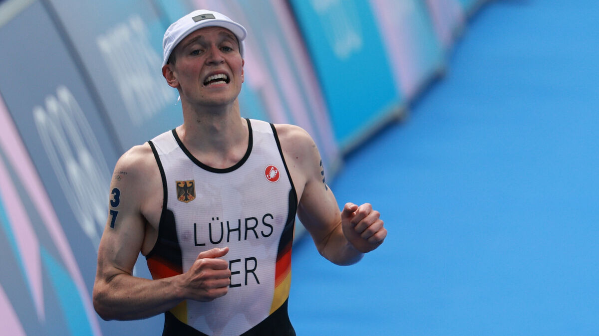 Sichtlich erschöpft: Lasse Lührs beim Triathlon bei den Olympischen Spielen in Paris auf dem Weg zur Ziellinie. Foto: dpa/Jan Woitas