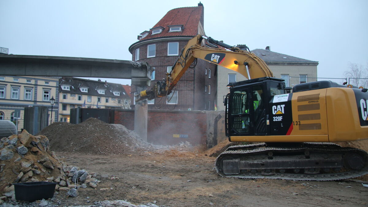 Der kleine Kraftprotz „CAT 320 F“ der Abrissfirma Bodo Freimuth setzt die grobe Betonschere an den ersten Pfeiler des Brückenbauwerkes am Cuxhavener Slippen an. Foto: Potschka