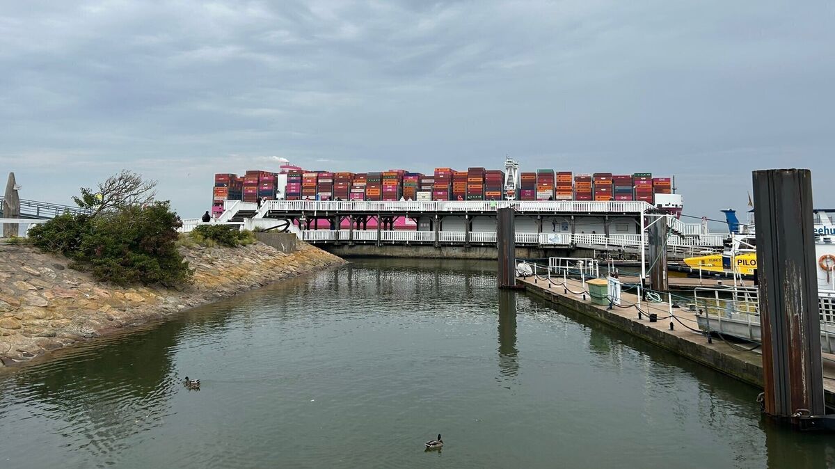 Ein Container-Riese zieht in Cuxhaven an der Alten Liebe vorbei. Es sieht fast so aus, als ob die Container auf der Aussichtsplattform stehen. Foto: Norbert König