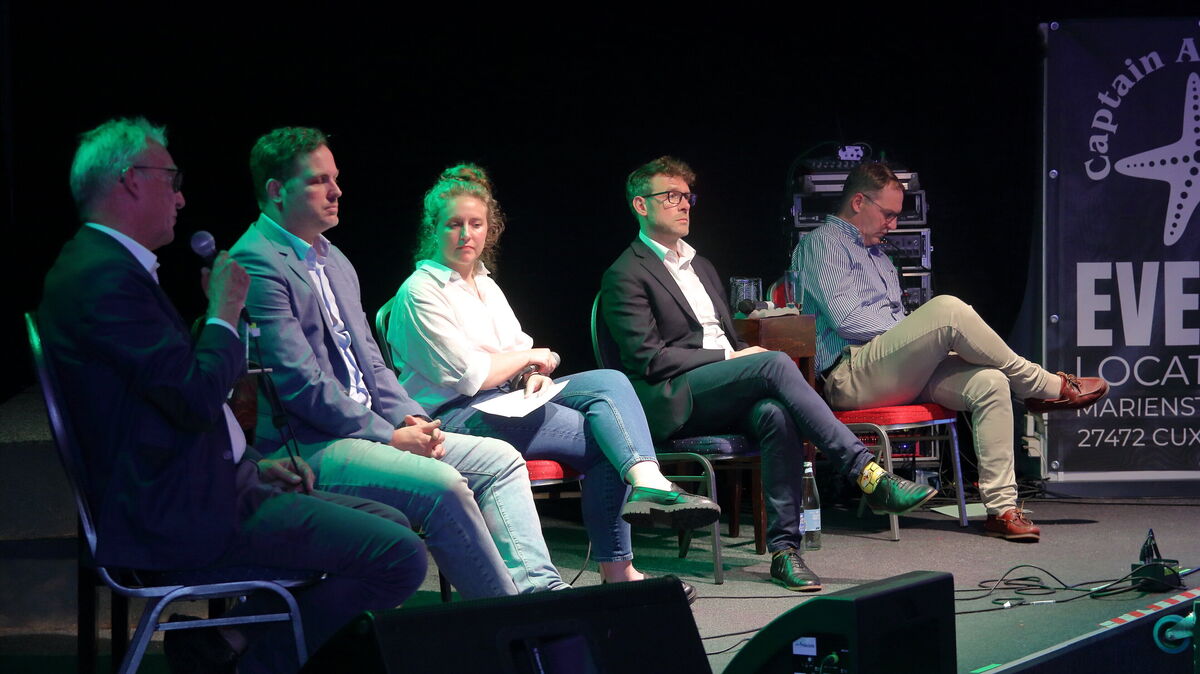 Auf dem Podium begrüßte Moderatorin Johanna Reusch (M.) den ehem. Staatssekretär Stefan Wenzel, Andreas Mummert (Stiftung Offshore Windenergie), den Meeres-Raumordner Hanno Salecker (BSH)  sowie Kapitän Arne Ehlers (Hafenwirtschaftsgemeinschaft/ Blue Water BREB, v. l.). Foto: Koppe