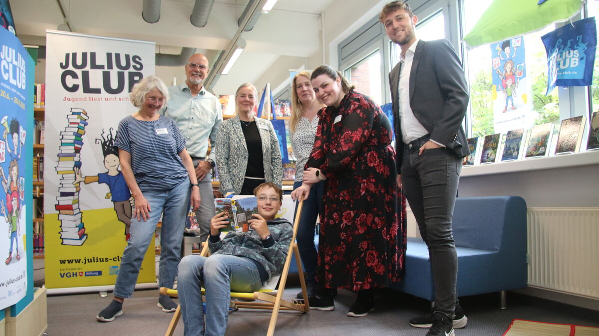 Versammelt in der eigens gestalteten Julius-Club-Leseecke: Ina Jäkel, Michael Lichte, Astrid Hebel, Nadia Niemann sowie Stephanie Lüder und Niclas Bode gemeinsam mit dem zwölfjährigen Frederik, der sich schon auf die Sommerlektüre freut. Die beiden Herren auf dem Bild vertreten die VGH-Stiftung, die den Julius-Lese-Club auch in diesem Sommer wieder sponsert.