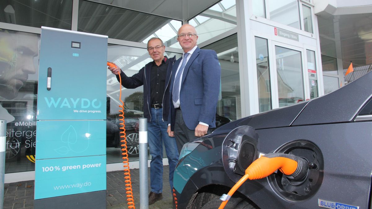 Autohändler Rainer Nübel (l.) und Tönjes Itgen von EWE/Waydo haben für die erste "Tankstelle"für Elektroautos in Altenbruch gesorgt. Nübel freut sich auch deshalb darüber, weil sein Großvater an gleicher Stelle die erste Gasolin-Tankstelle betrieben hat. Foto: Sassen