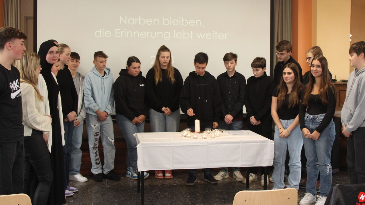 Neuntklässler der Geschwister-Scholl-Schule zündeten eine Kerze im Gedenken an alle Opfer von Krieg und Verfolgung an und beendeten das Gedenken mit einer Schweigeminute.Foto: Reese-Winne