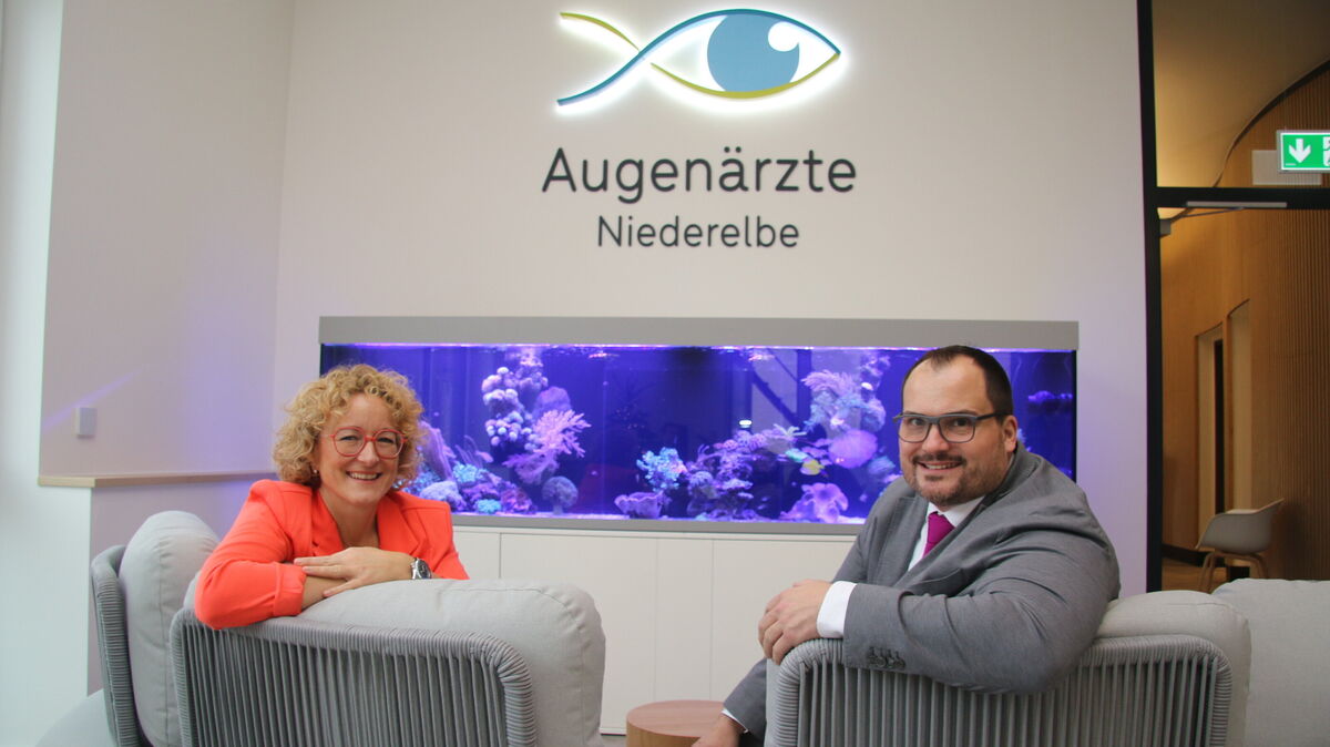 Ein echter Hingucker: Die Fachärztin Alexandra Heuvels und Dr. med. Per Heuvels freuen sich über das große Aquarium im Wartebereich ihrer neuen Praxis, das einen Hauch von Meereswelt in die Augenheilkunde bringt und Patienten jeden Alters begeistert. Foto: Potschka