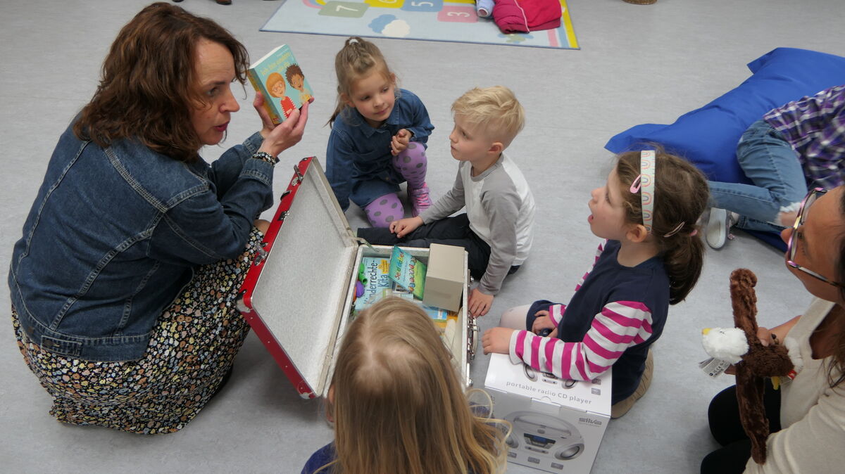 Bürgermeisterin Sabine Wist übergibt Kitakindern einen Kinderrechtekoffer. Darin gibt es Bilderbücher, Hörspiele und viel Infomaterial, mit dem die Erzieherinnen den Kindern Akzeptanz Selbstwertgefühl und Sicherheit vermitteln können. Foto: Wist