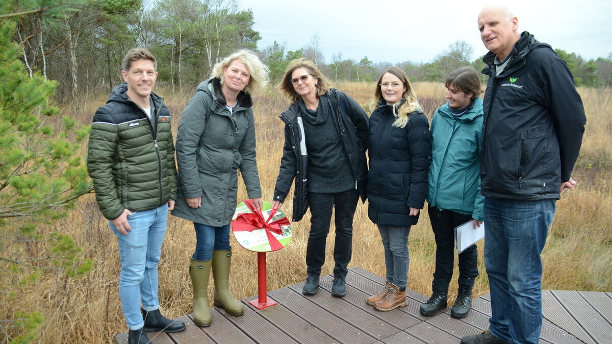 Die Infotafel zum Projekt „KlimaMoor am Löh“ im Ahlenmoor wird enthüllt: Im Zeitraum von fünf Jahren wurden 50 Hektar wiedervernässt, um eine hochmoortypische Vegetation zu schaffen und Kohlenstoff zu binden. Finanziert wurde das über CO2-Zertifikate durch den freiwilligen Emissionshandel. Foto: Rohde