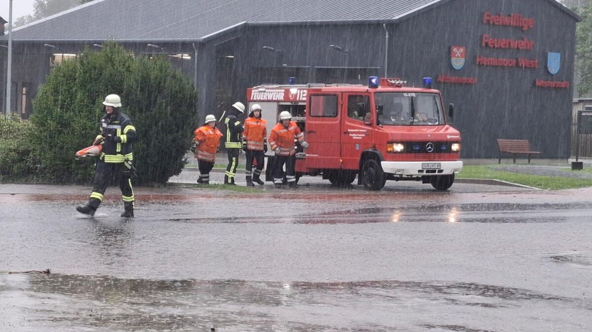 Feuerwehrleute der Freiwilligen Feuerwehr Hemmoor-West im Einsatz bei Starkregen: Das Unwetter führte in Hemmoor unter anderem in Warstade und Westersode zu überfluteten Straßen, Kellern und Häusern. Foto: Jürgen Lange