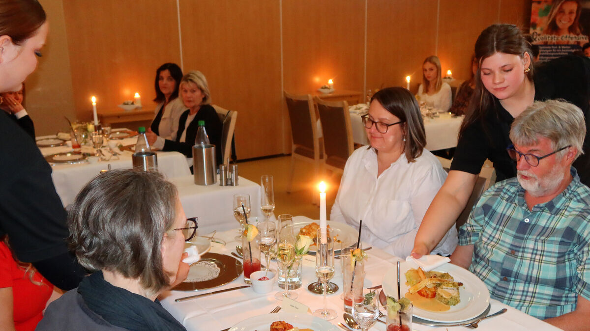 Echte Gastfreundschaft geht weit über ein freundliches Lächeln hinaus, wissen Joy Flathmann (l.) und Yasmine Appelstiel. Sie servieren den Gästen das Mittagessen. Foto: Tonn