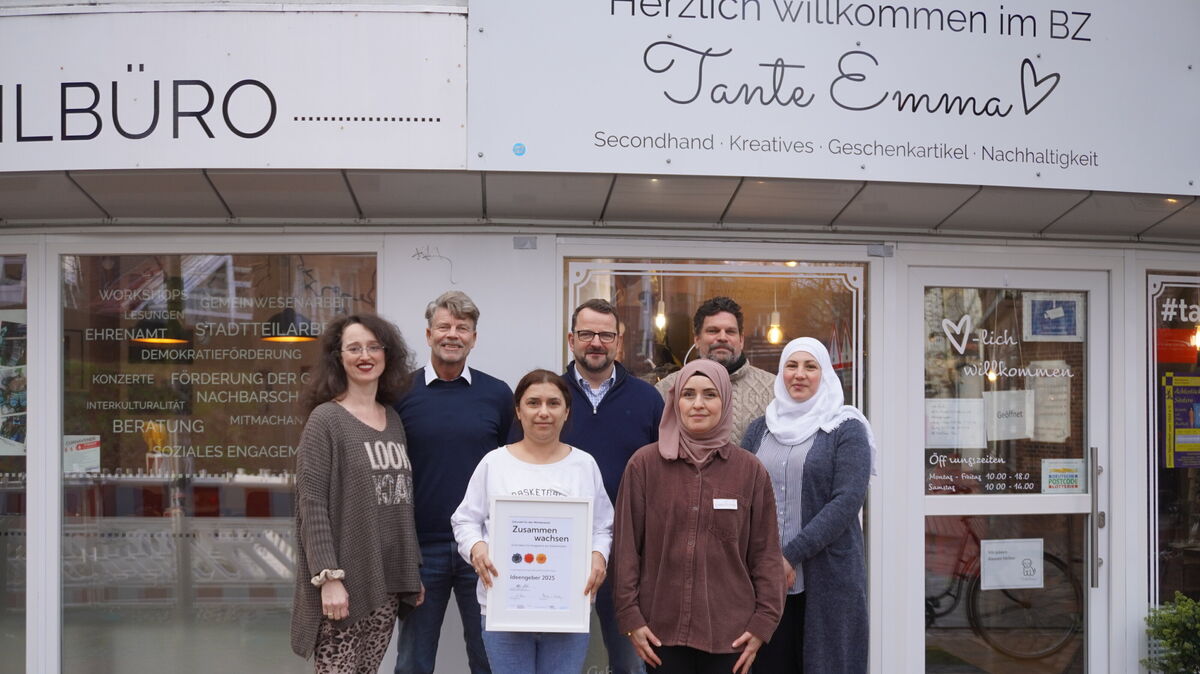 Elvira Heymann (l.), Bodo Mayerhof (2 v.l.), Sven Wersien (m.), Sven Mangels (2 v.r. hintere Reihe) mit Almaz Ahmed (Verkäuferin bei Tante Emma), Haifaa Abou Khaled und Ludmilla Popa (ehrenamtliche Verkäuferinnen). Foto: Brettschneider
