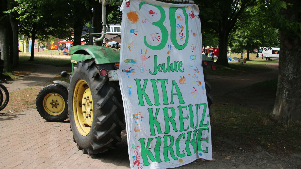 Ein historischer Trecker mit buntem Plakat begrüßt die Gäste zum 30. Jubiläum der Kita Kreuzkirche Altenwalde im Bürgerpark. Foto: Potschka