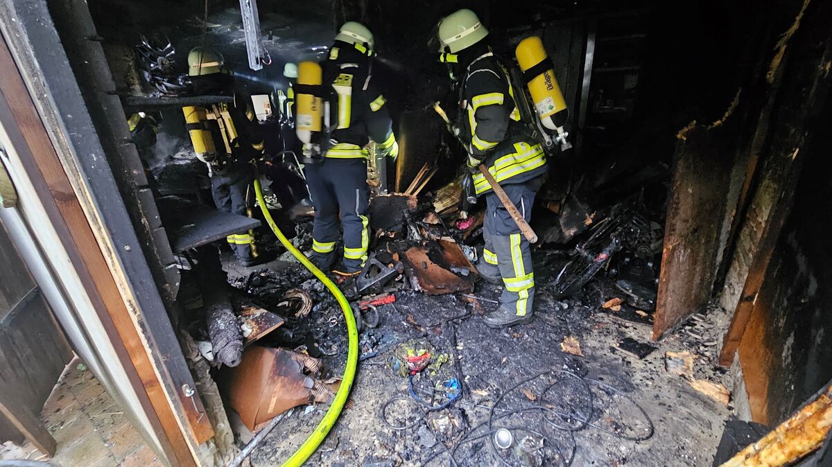 Nach Ablöschen des Feuers wird das verbrannte Inventar auseinandergezogen und ins Freie transportiert. Foto: Lange