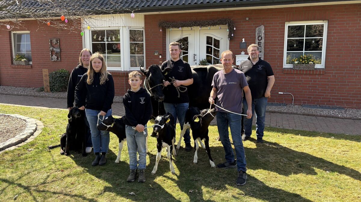 Meike und Jürgen Oellerich mit ihren drei Kindern Nika, Jaron und Finn sowie Tierzuchttechniker Volker Stemmermann präsentieren die Kuh Somalia mit ihren Kälbern Sina, Simba und Samba. Auch Hund Paula kam mit aufs Bild. Foto: Björn Wienberg