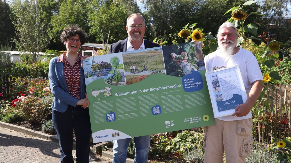 Mira Hohmann von der Nationalparkverwaltung, Oberbürgermeister Uwe Santjer und der Vorsitzende des KGV Döse-Nord, Thomas Meyer, enthüllen die neue Infotafel. Foto: Larschoiw