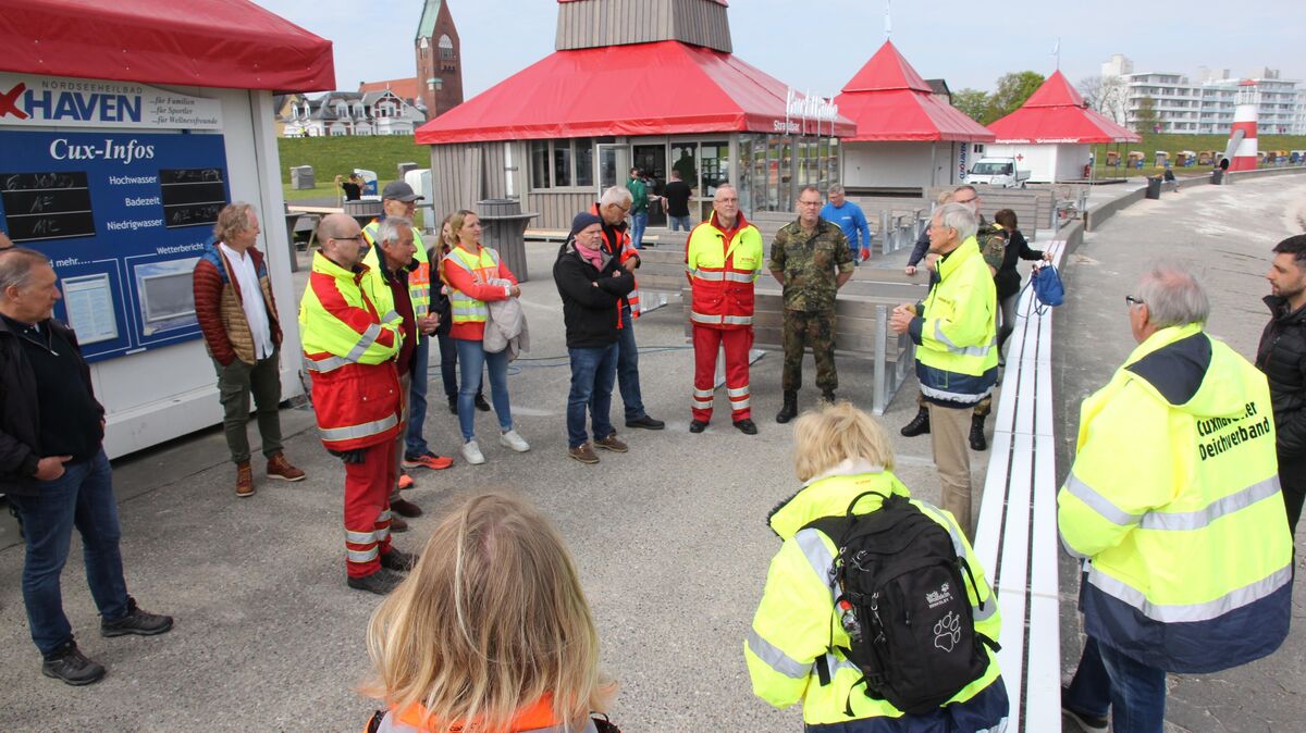 Mitglieder und Gäste des Cuxhavener Deichverbandes informierten sich am Freitag bei der Frühjahrsdeichschau darüber, wie der neue Pächter die Außenanlagen innerhalb der Betonplatte befestigt hat. Nach der Saison muss alles, was die Deichsicherheit beeinträchtigt, wieder abgebaut werden. Foto: Sassen