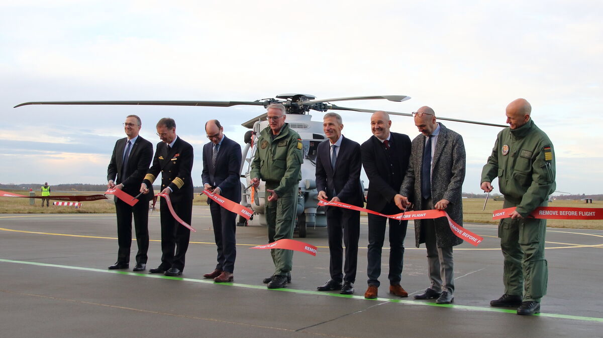 Übergabe des ersten NH 90 Sea Tiger: Das Band, das Kommandeur Broder Nielsen (M., mit Partnern aus Marine und Industrie) durchtrennte, bildete die letzte (symbolische) Hürde, die es am Dienstag zu nehmen galt. Foto: Koppe