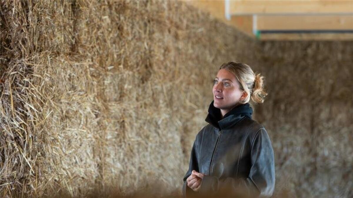Architektin Anna Dienberg steht Im Rohbau des Dorfgemeinschaftshauses mit Wänden aus Stroh. Foto: Swen Pförtner/dpa