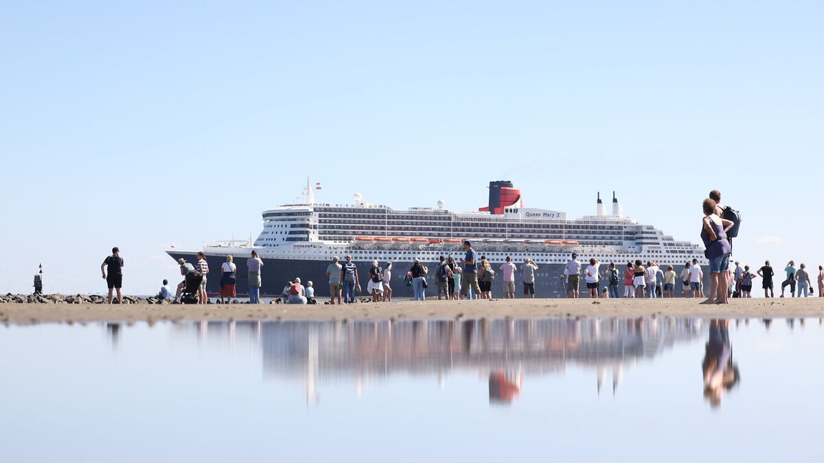 Hunderte Interessierte und Schiff-Fans verfolgen mit ihren Blicken die „Queen Mary 2“, als der Ozeanliner vor Cuxhaven vorbeizieht. Foto: Larschow