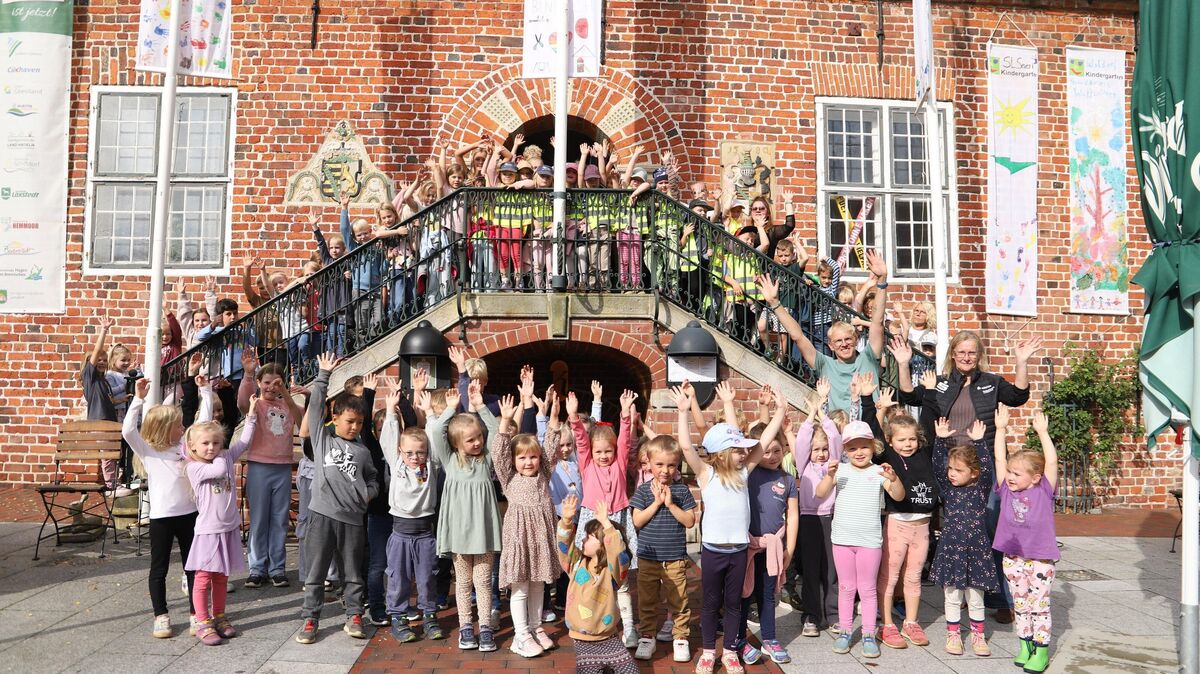 Kinderrechte im Fokus: Vor dem Rathaus der Medemstadt versammelten sich die Kinder, um mit bunten Fahnen und fröhlichen Liedern auf den Weltkindertag aufmerksam zu machen. Foto: Larschow