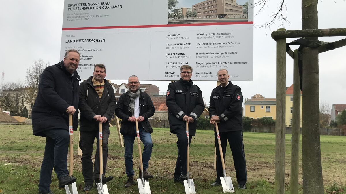 Oberbürgermeister Uwe Santjer, Projektleiter Lorenz Tettenborn, Stefan Müller, Leiter des Staatlichen Baumanagements Elbe-Weser, Andreas Sagehorn, Vizepräsident der Polizeidirektion Oldenburg, und Arne Schmidt, Leiter der Polizeinspektion Cuxhaven (v.l.), griffen unter dem Bauschild symbolisch zum Spaten. Foto: Reese-Winne