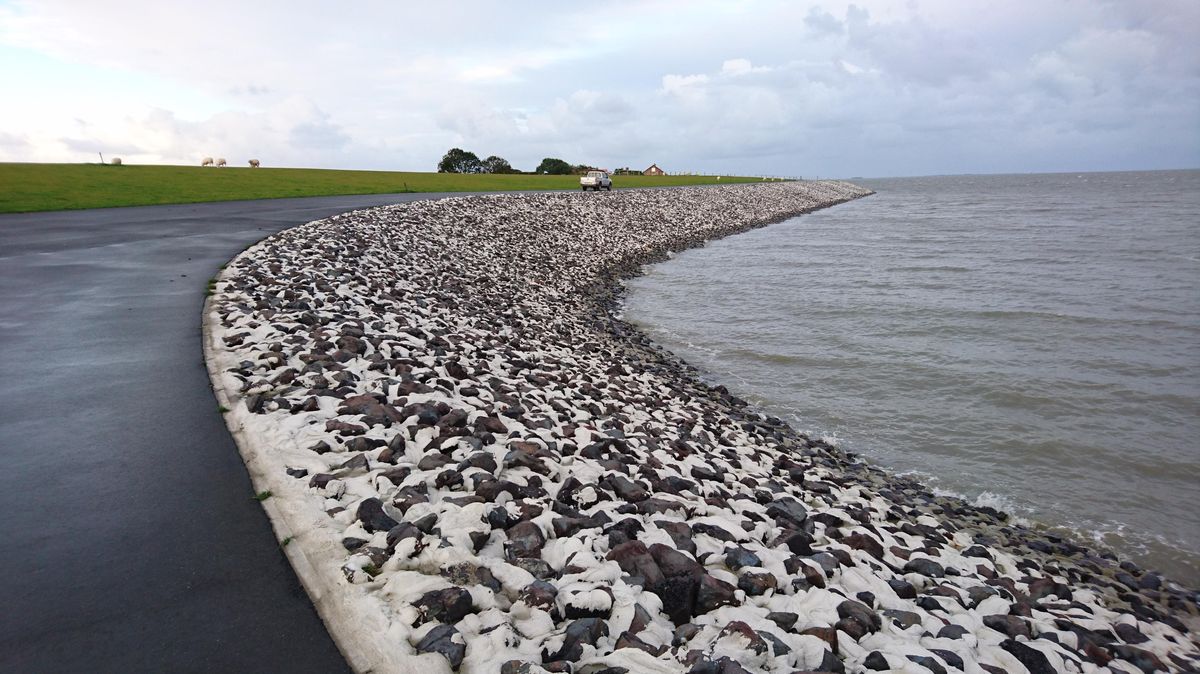 Läuft sehr flach aus: der im Frühjahr 2017 eingeweihte Klimadeich auf Nordstrand, im Westen der Hafenstadt Husum (Schleswig-Holstein). Er ist 8,70 Meter hoch - und er kann noch weiter wachsen. Foto: Landesbetrieb für Küstenschutz, Nationalpark und Meeresschutz Schleswig-Holstein