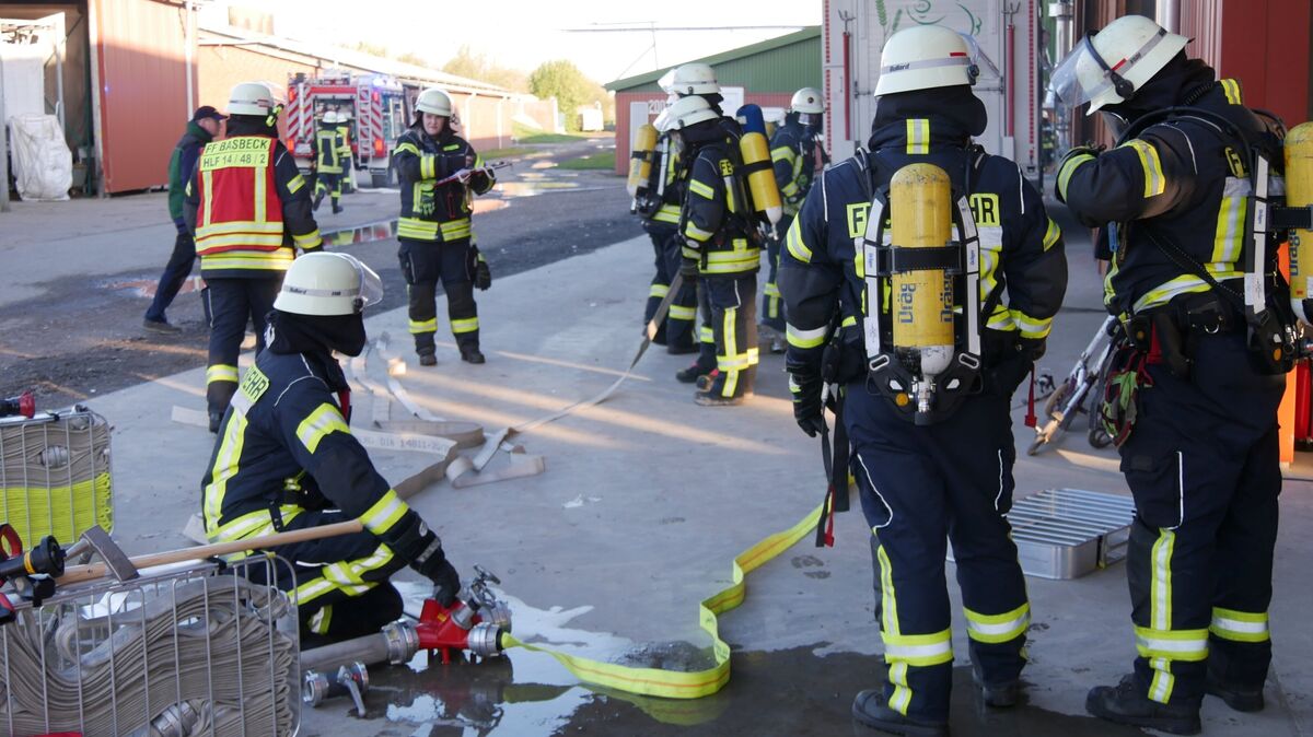 Der Löschangriff wird über lange Wegstrecke mit Schlauchverlegung aufgebaut. Gleichzeitig rüsten sich mehrere Atemschutzgeräteträger für die Vermisstensuche mit schwerem Atemschutz aus. Foto: Lange