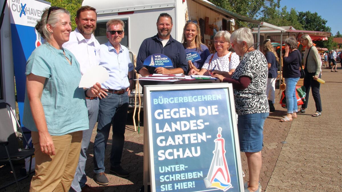 Über eine auf dem Wochenmarkt ausliegende Unterschriftenliste möchten die Initiatoren (hier mit Unterstützern aus der Wählergemeinschaft Die Cuxhavener und Passanten) einen Bürgerentscheid auf den Weg bringen: Eine Landesgartenschau in Cuxhaven zu verhindern ist das Ziel der Initiative. Foto: Koppe