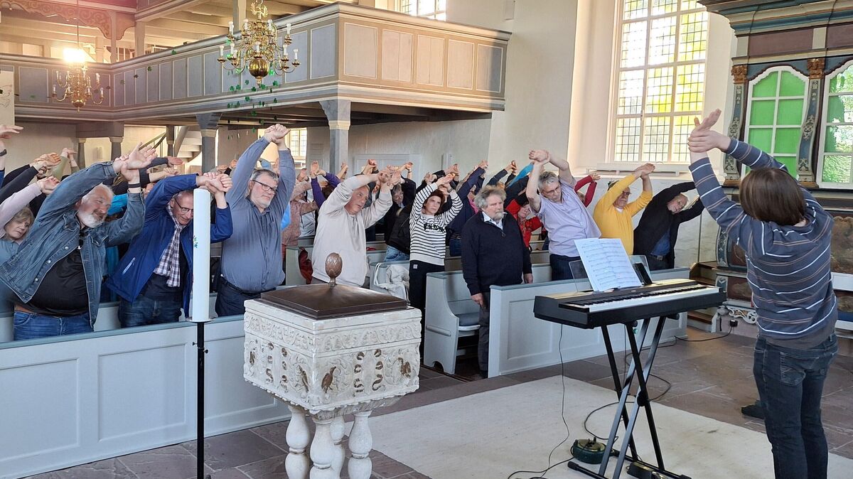 Der Körper singt mit: Popkantor Valentin Behr (rechts) lässt zum Auftakt der Chorprobe erst einmal ein paar Dehnungsübungen ausführen. Foto: Kirchenkreis/ Schoener